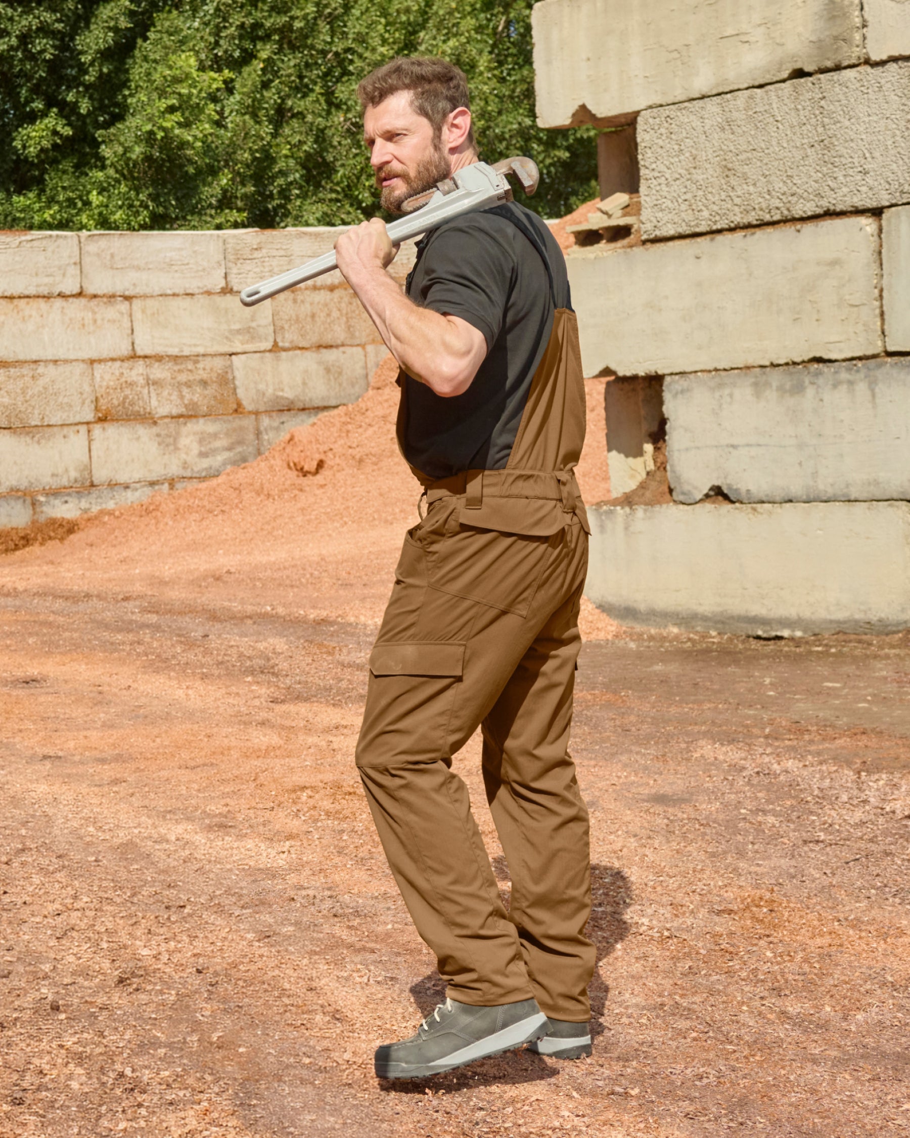 desert brown STRAUSS Stretch Ripstop Cargo Work Bib Overall e.s.taktik shown in use at a jobsite