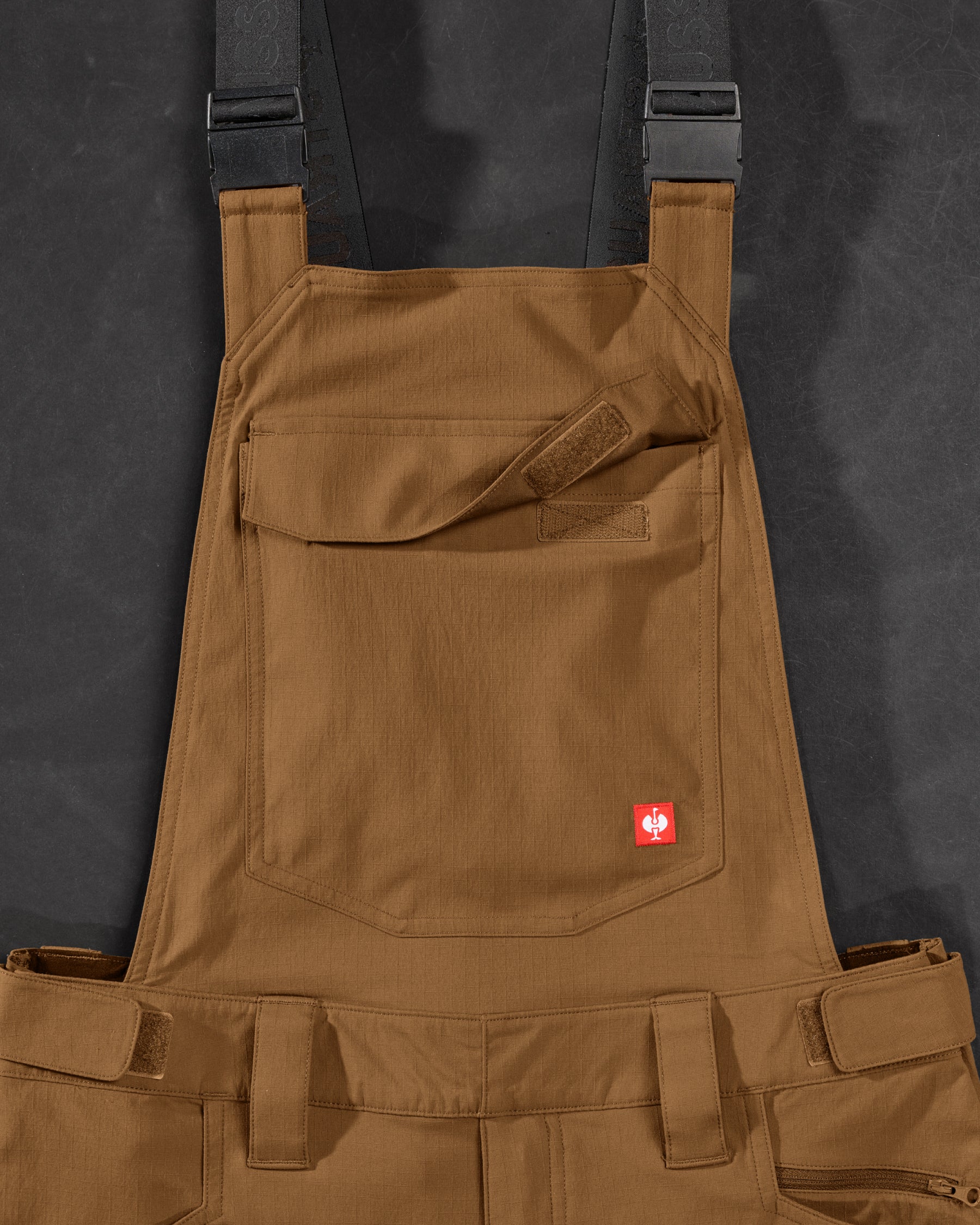Close-up of desert brown STRAUSS Stretch Ripstop Cargo Work Bib Overall e.s.taktik seam, hardware, and workwear details