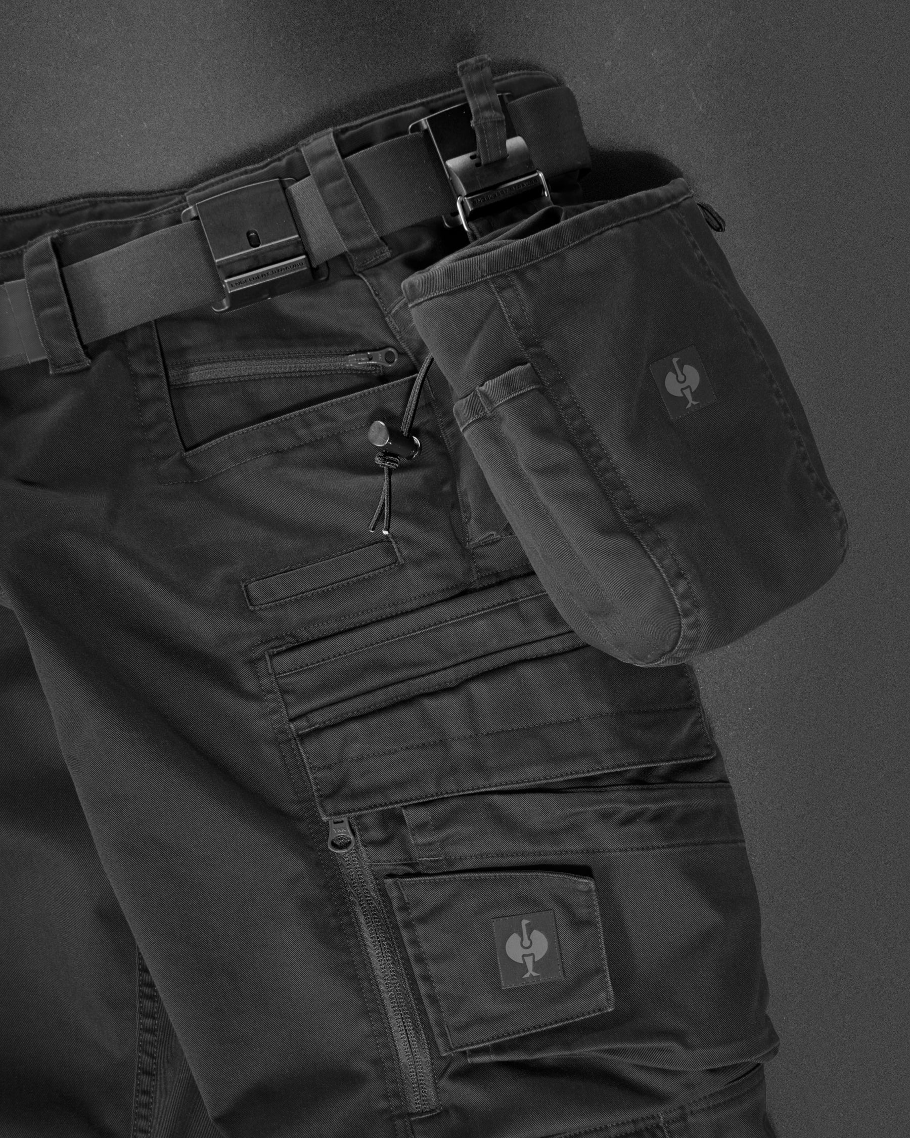 Close-up of the oxid black STRAUSS e.s.motion ten nail bag holding small fasteners on a work belt.