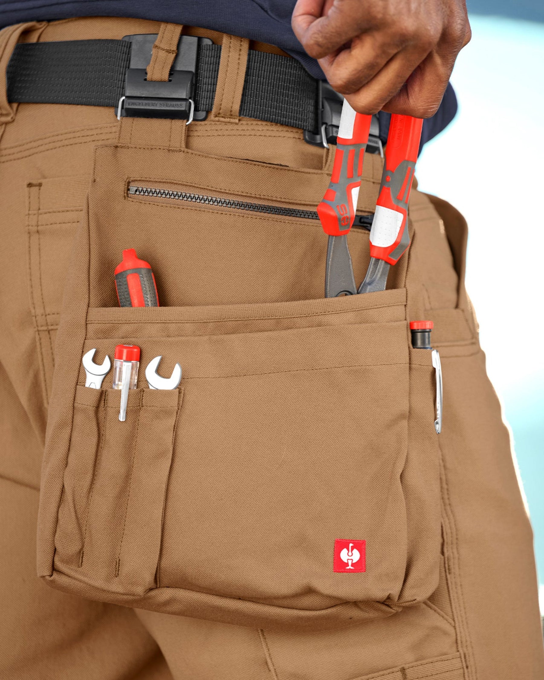 Close-up of pockets, loops, clips, and reinforced stitching on the almond brown STRAUSS e.s.iconic tool bag.