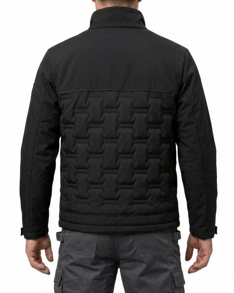 A man viewed from the back wearing a black quilted jacket with a distinctive geometric patterned back panel and dark gray cargo pants, set against a plain white background.