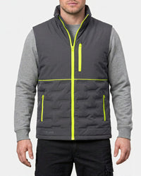 A man wearing a dark gray quilted zip-up vest over a heather gray long-sleeve shirt, with bright neon yellow-green trim details, against a light gray background.