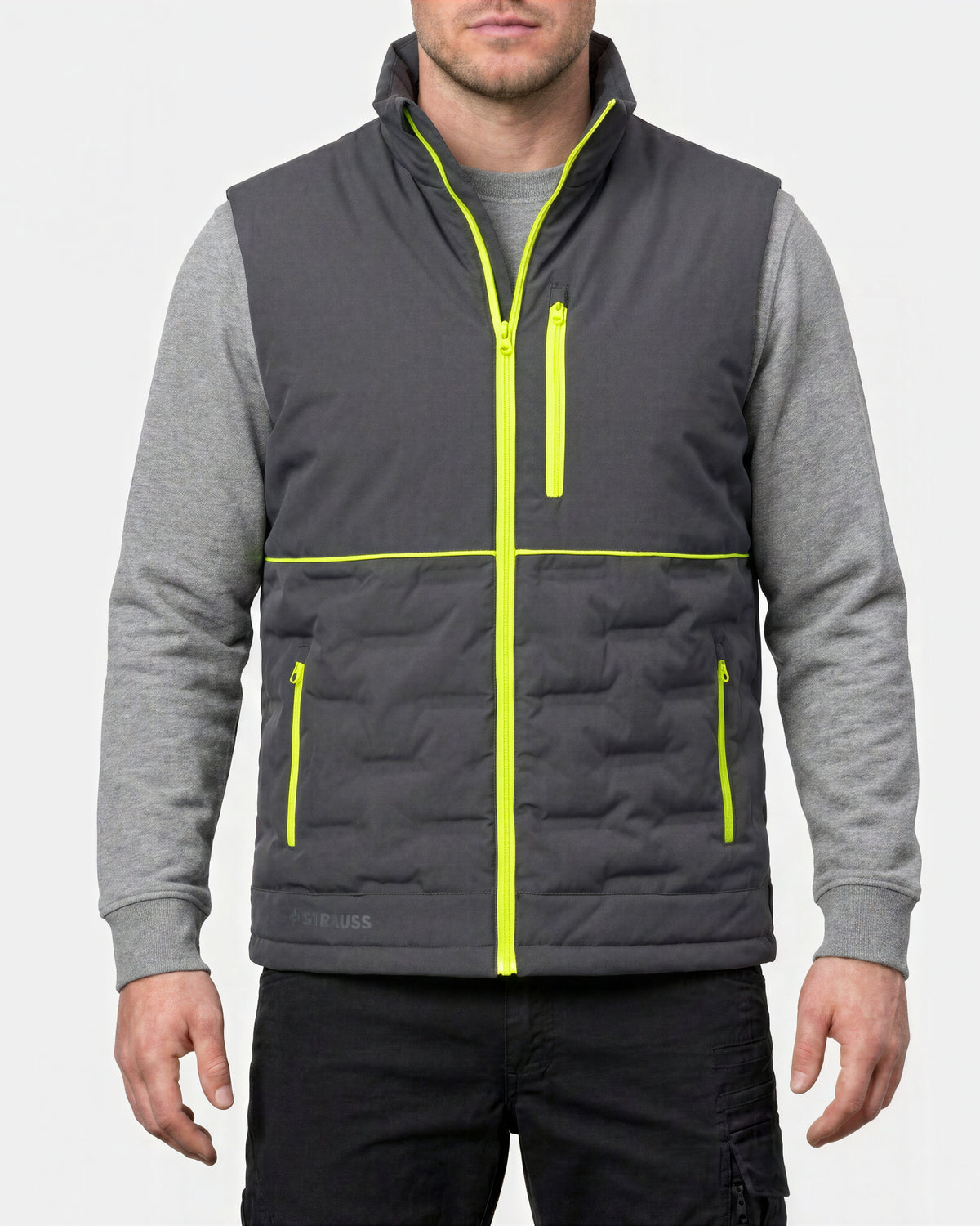 A man wearing a dark gray quilted zip-up vest over a heather gray long-sleeve shirt, with bright neon yellow-green trim details, against a light gray background.