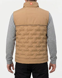 A man viewed from the back wearing a tan quilted vest over a gray long-sleeve shirt and black pants, against a plain light gray studio background.