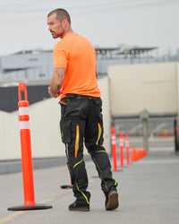 Cargo Work Pants e.s.motion 2020 in black/high-vis yellow-orange in use, showing fit and movement