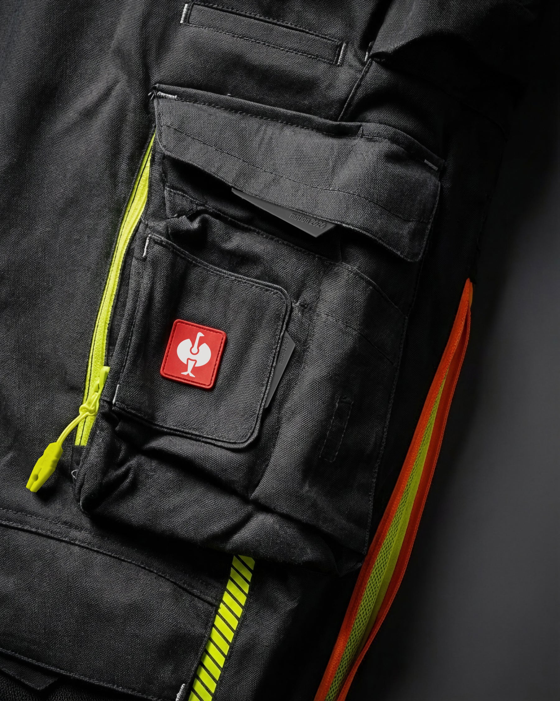Close-up of cargo pocket details on Cargo Work Pants e.s.motion 2020 in black/high-vis yellow-orange