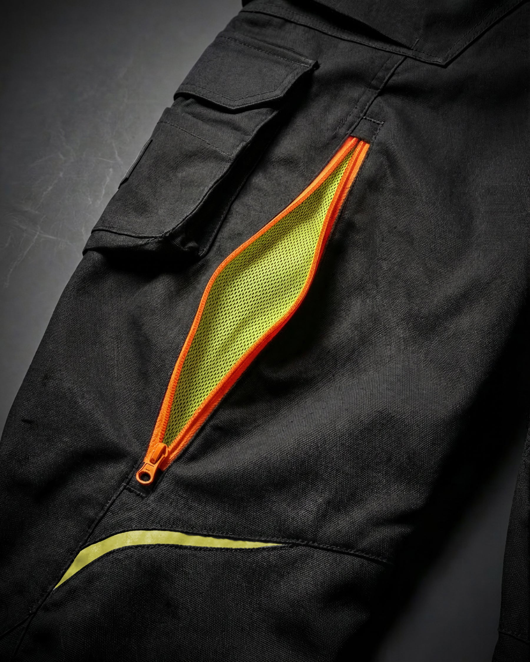 Close-up of zipper vents on Cargo Work Pants e.s.motion 2020 in black/high-vis yellow-orange