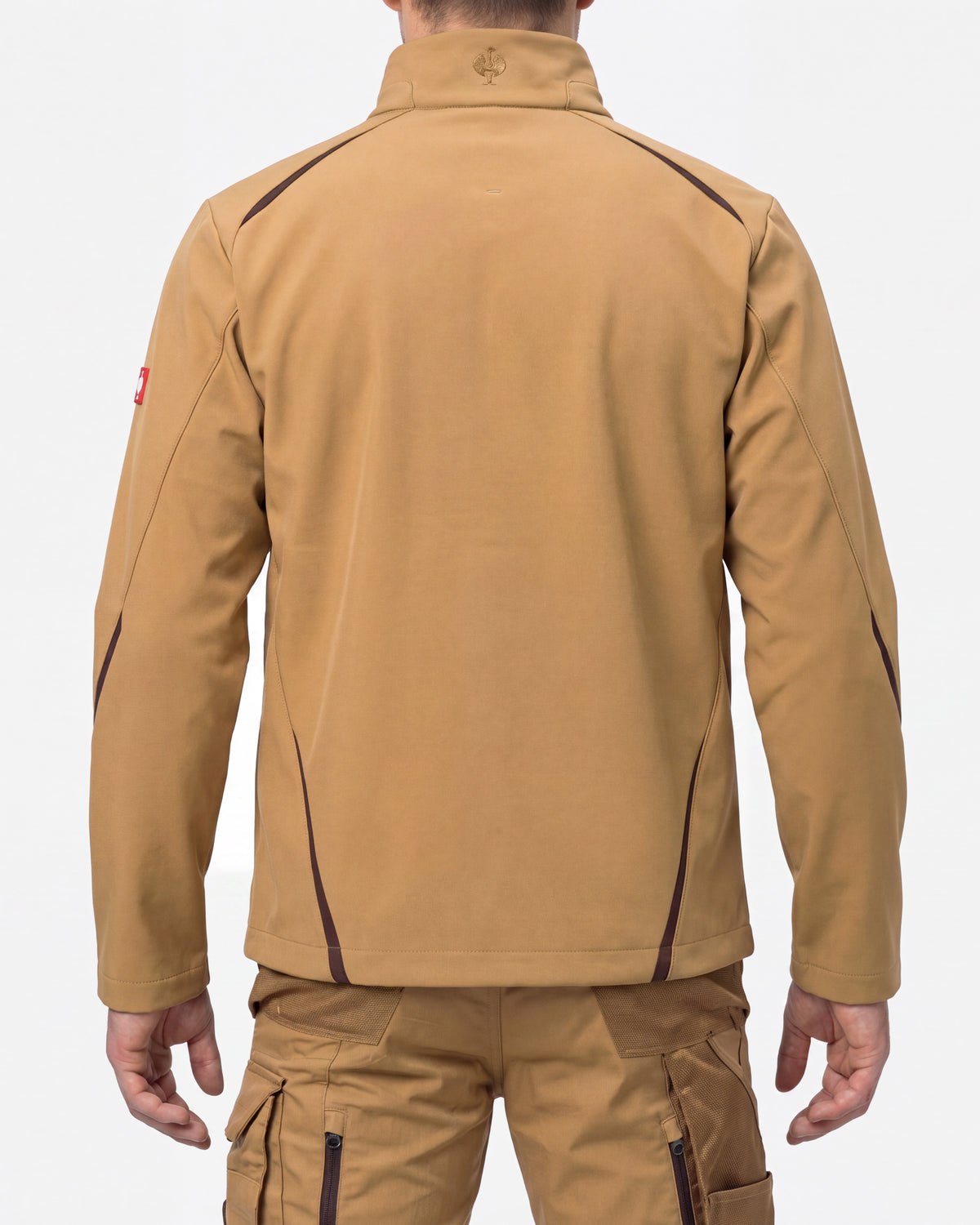 A man shown from the back wearing a tan zip-front jacket with dark contrast stitching and matching tan cargo pants against a light gray studio background.
