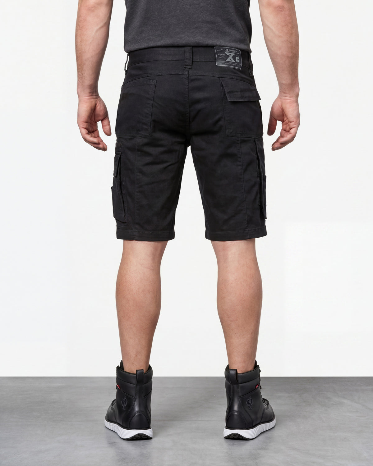 Alternate model view of Engelbert Strauss e.s. motion ten shorts in oxid black, showing the side and back fit with visible utility pocket placement and workwear construction.