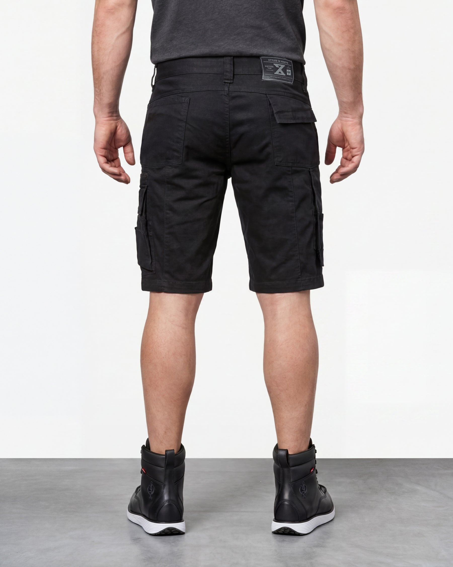 Alternate model view of Engelbert Strauss e.s. motion ten shorts in oxid black, showing the side and back fit with visible utility pocket placement and workwear construction.