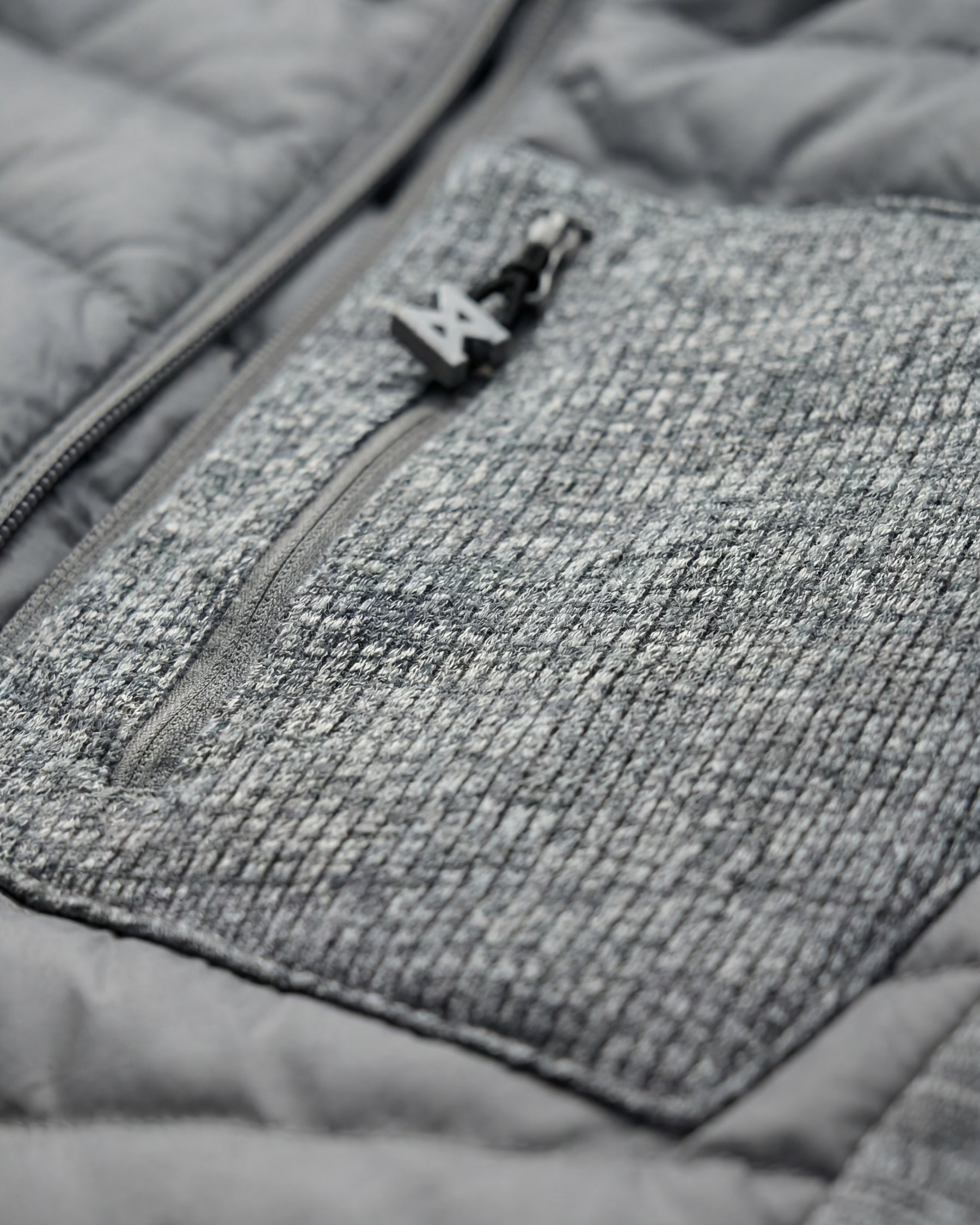 Close-up of quilted and stretch panel details on STRAUSS e.s.motion ten hybrid hooded jacket in gray melange