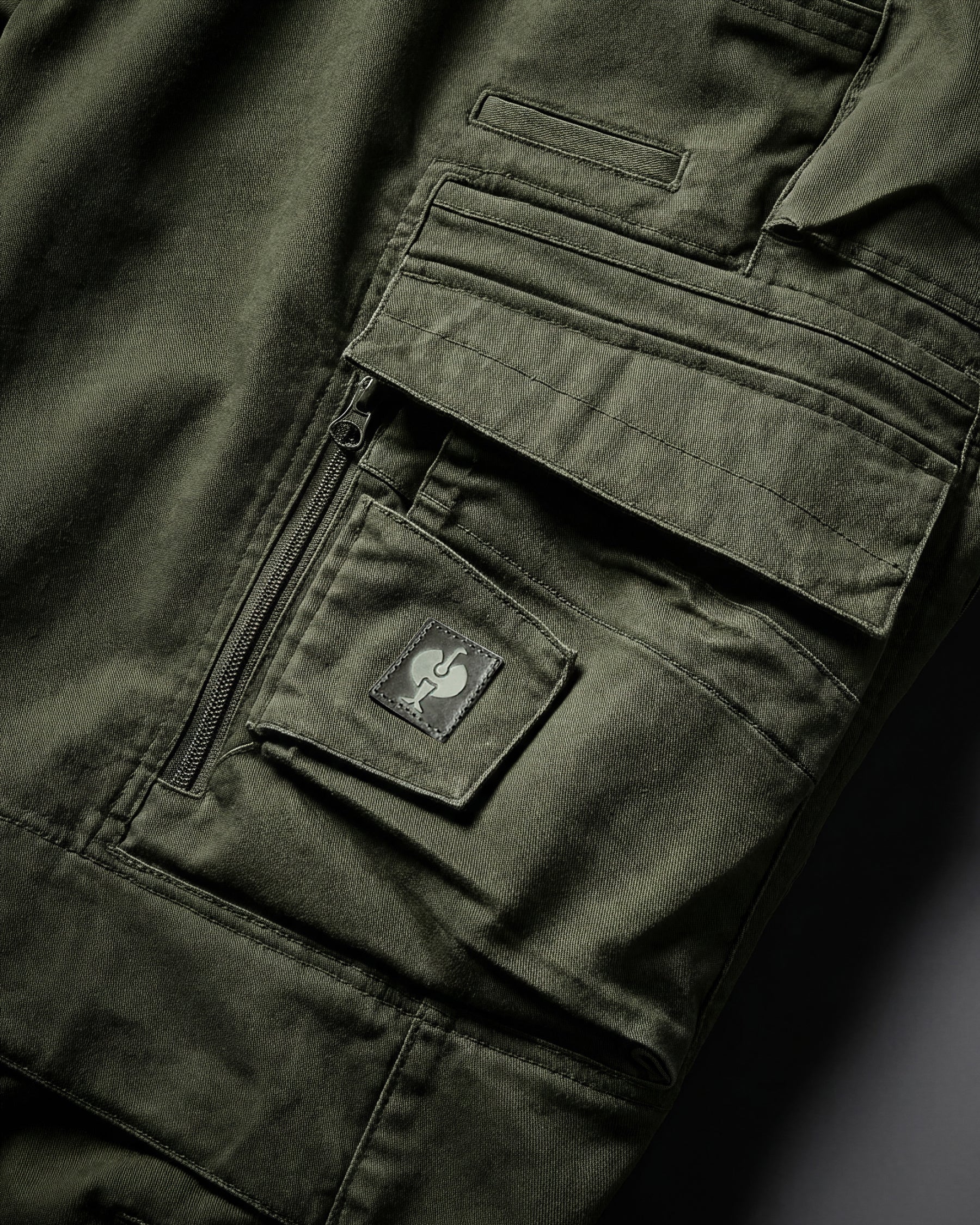 Close-up of cargo pocket details on Cargo Work Pants e.s.motion ten in disguise green