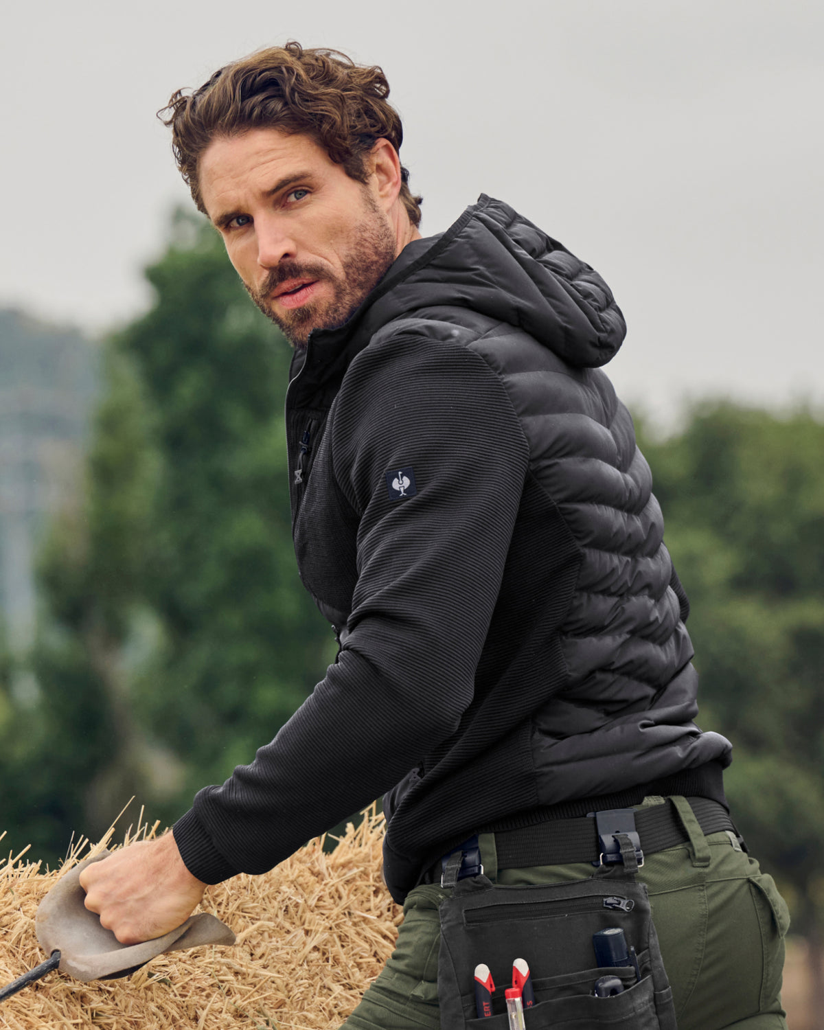 STRAUSS e.s.motion ten hybrid hooded jacket in black shown during outdoor work