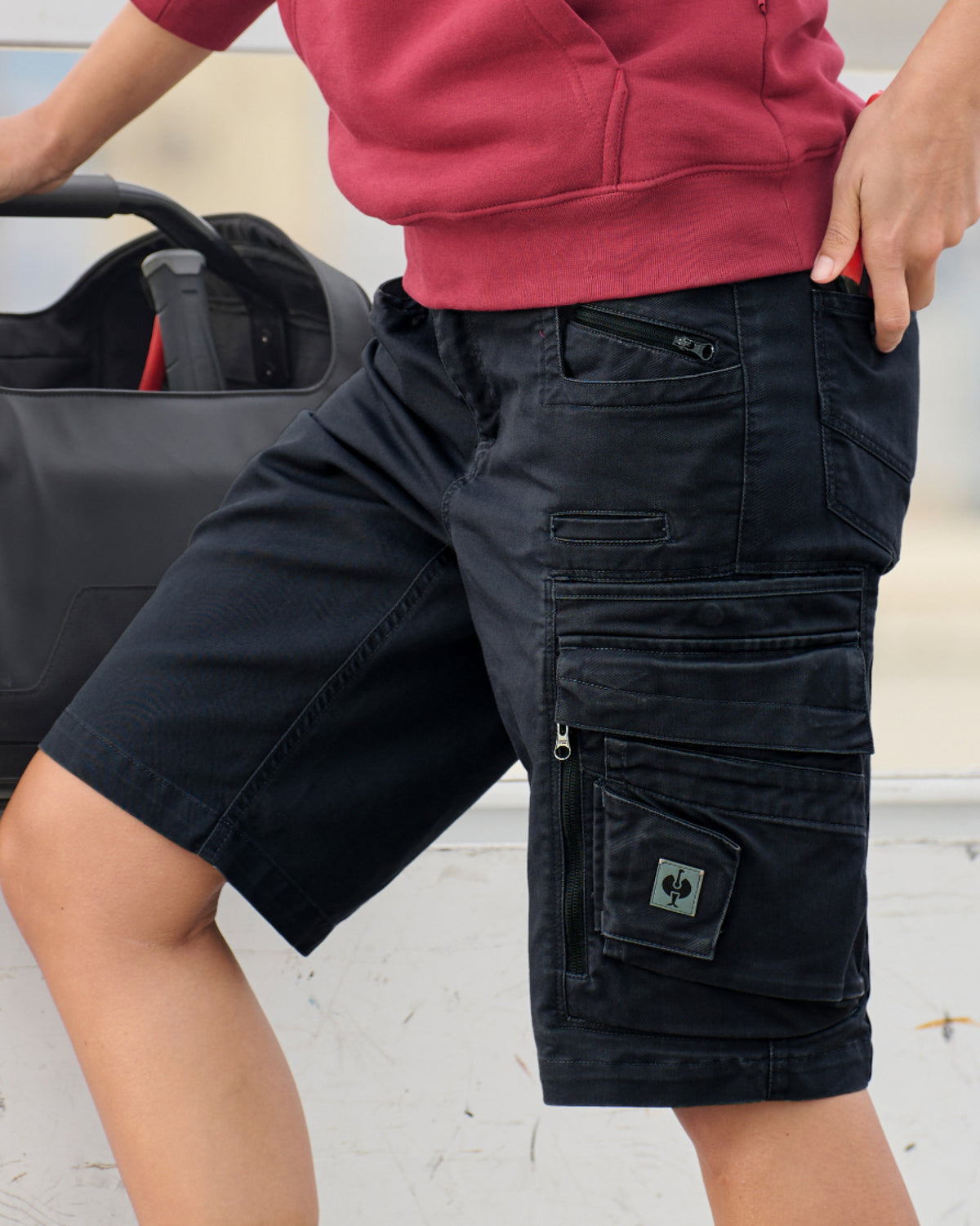 Engelbert Strauss women's e.s. motion ten shorts in oxid black in an outdoor-style lifestyle view, showing the shorts as part of a functional work outfit.