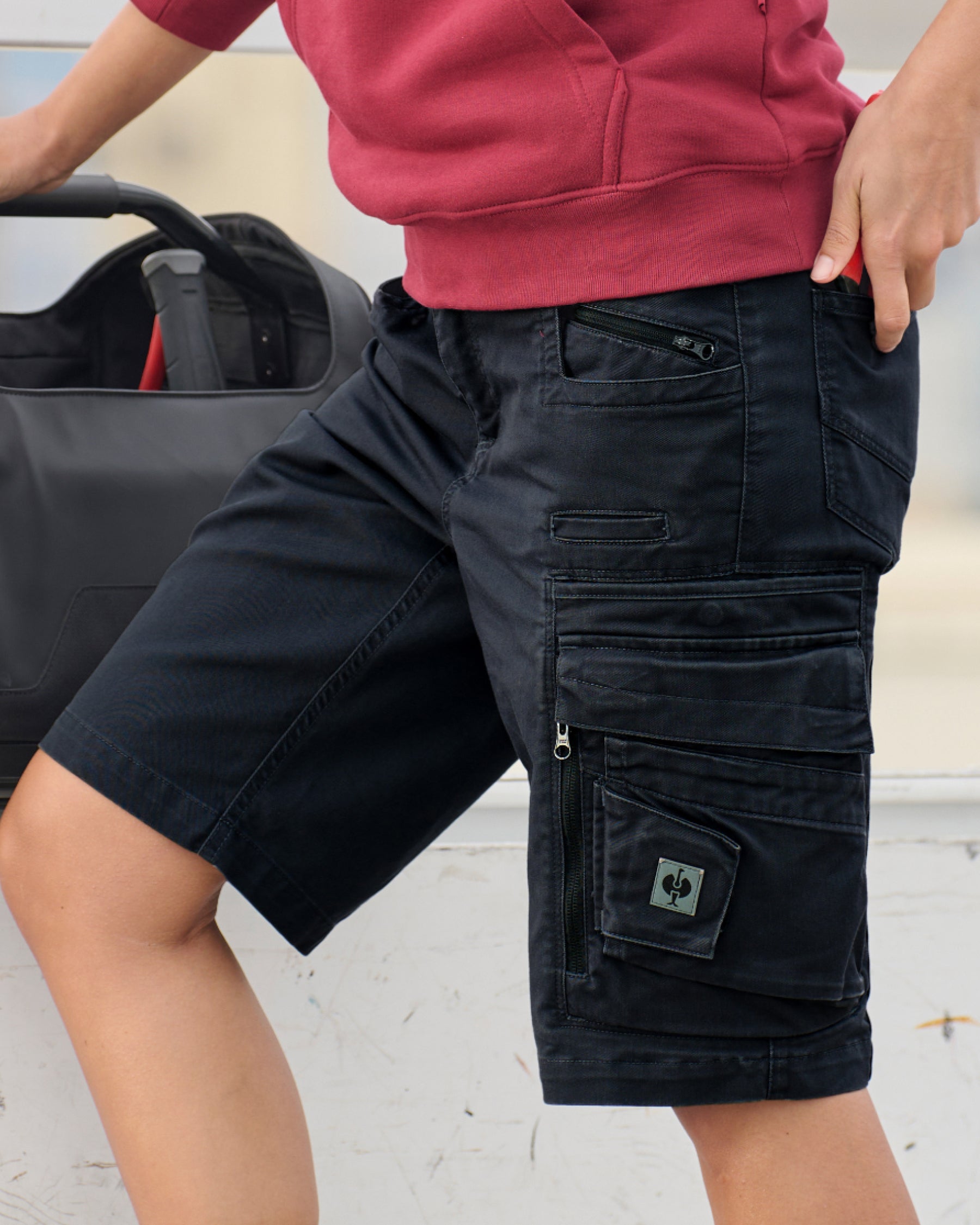Engelbert Strauss women's e.s. motion ten shorts in oxid black in an outdoor-style lifestyle view, showing the shorts as part of a functional work outfit.