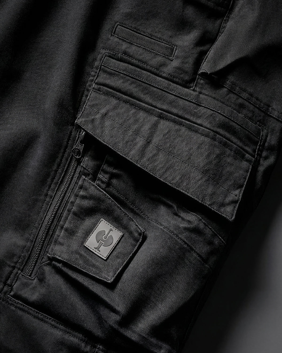 Close-up detail of Engelbert Strauss women's e.s. motion ten shorts in oxid black, focusing on the utility pocket area, seams, and reinforced workwear construction.