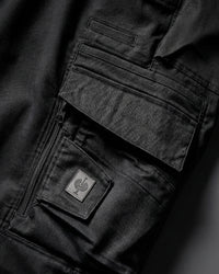 Close-up detail of Engelbert Strauss women's e.s. motion ten shorts in oxid black, focusing on the utility pocket area, seams, and reinforced workwear construction.