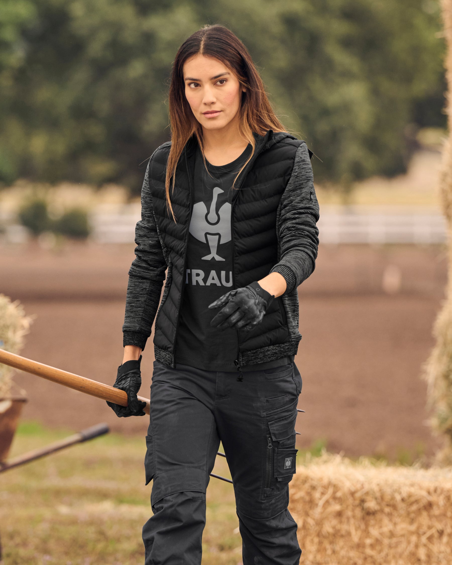 STRAUSS women's e.s.motion ten hybrid hooded jacket in oxid black melange shown during outdoor work
