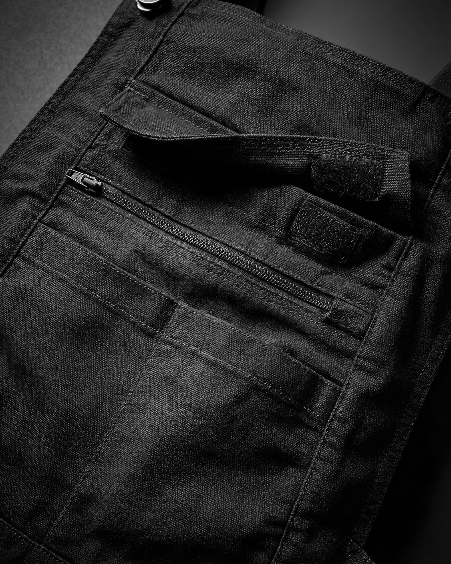 Close-up of black STRAUSS Multipocket Work Bib Overall e.s.vintage seam, hardware, and workwear details