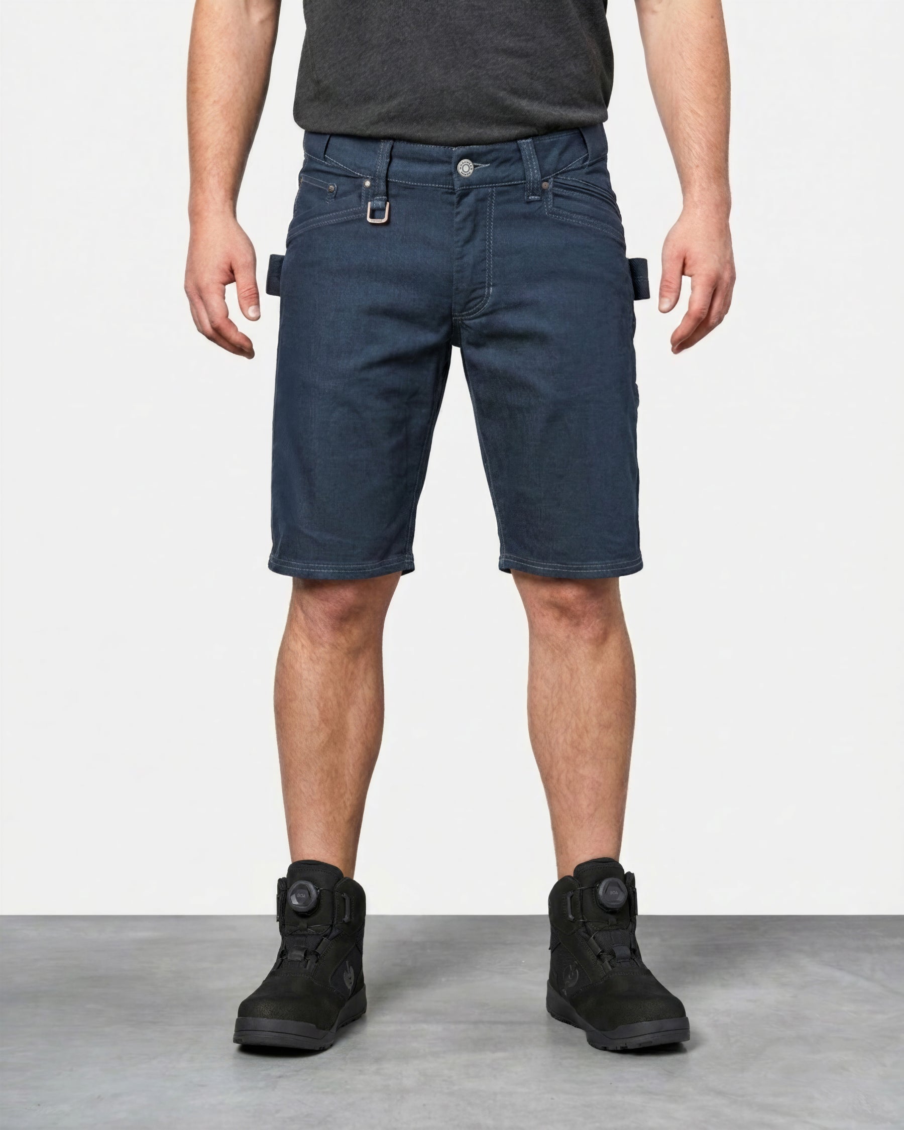 Model wearing Engelbert Strauss e.s. vintage multipocket shorts in arctic blue, showing the fit, length, waistband, and front pocket layout of the rugged multipocket work shorts with a vintage workwear look.