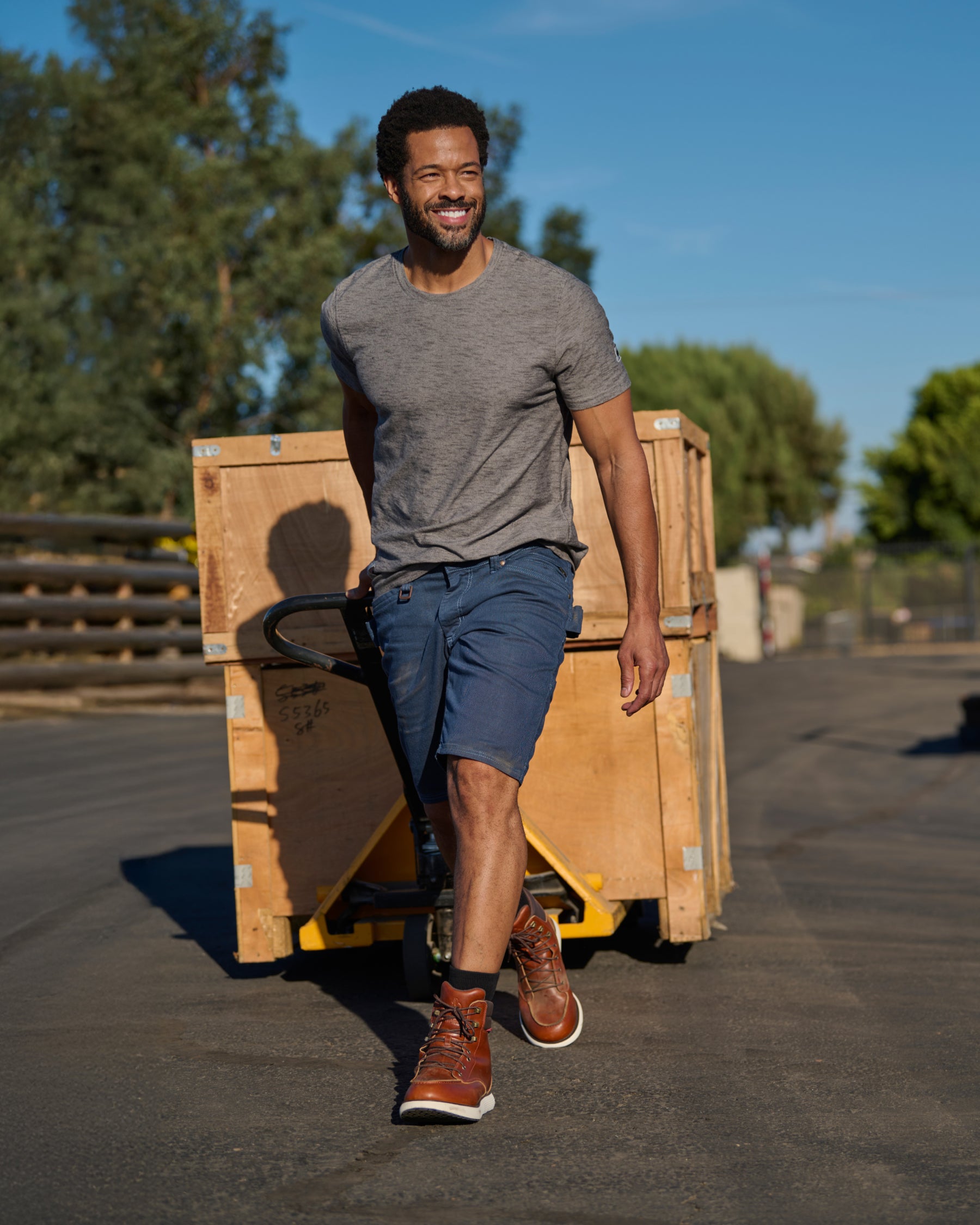 Engelbert Strauss e.s. vintage multipocket shorts in arctic blue in a lifestyle action view, highlighting the practical pocket access and durable workwear silhouette.