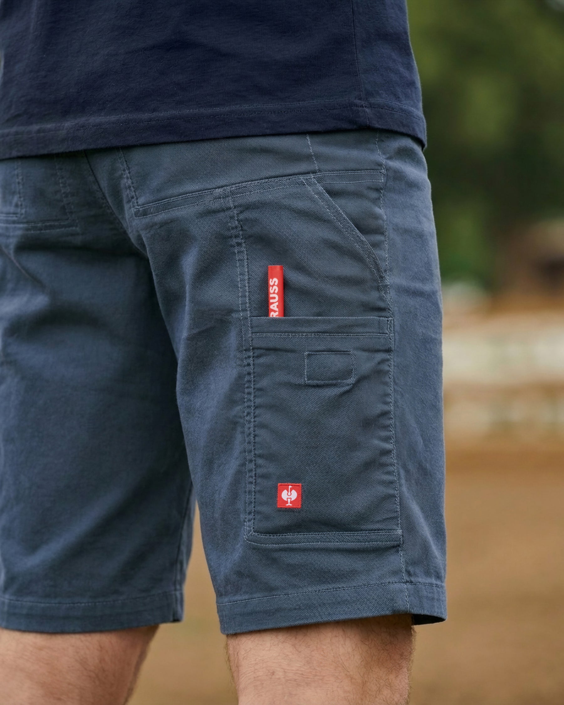 Close-up detail of Engelbert Strauss e.s. vintage multipocket shorts in arctic blue, focusing on the utility pocket area, seams, and reinforced workwear construction.