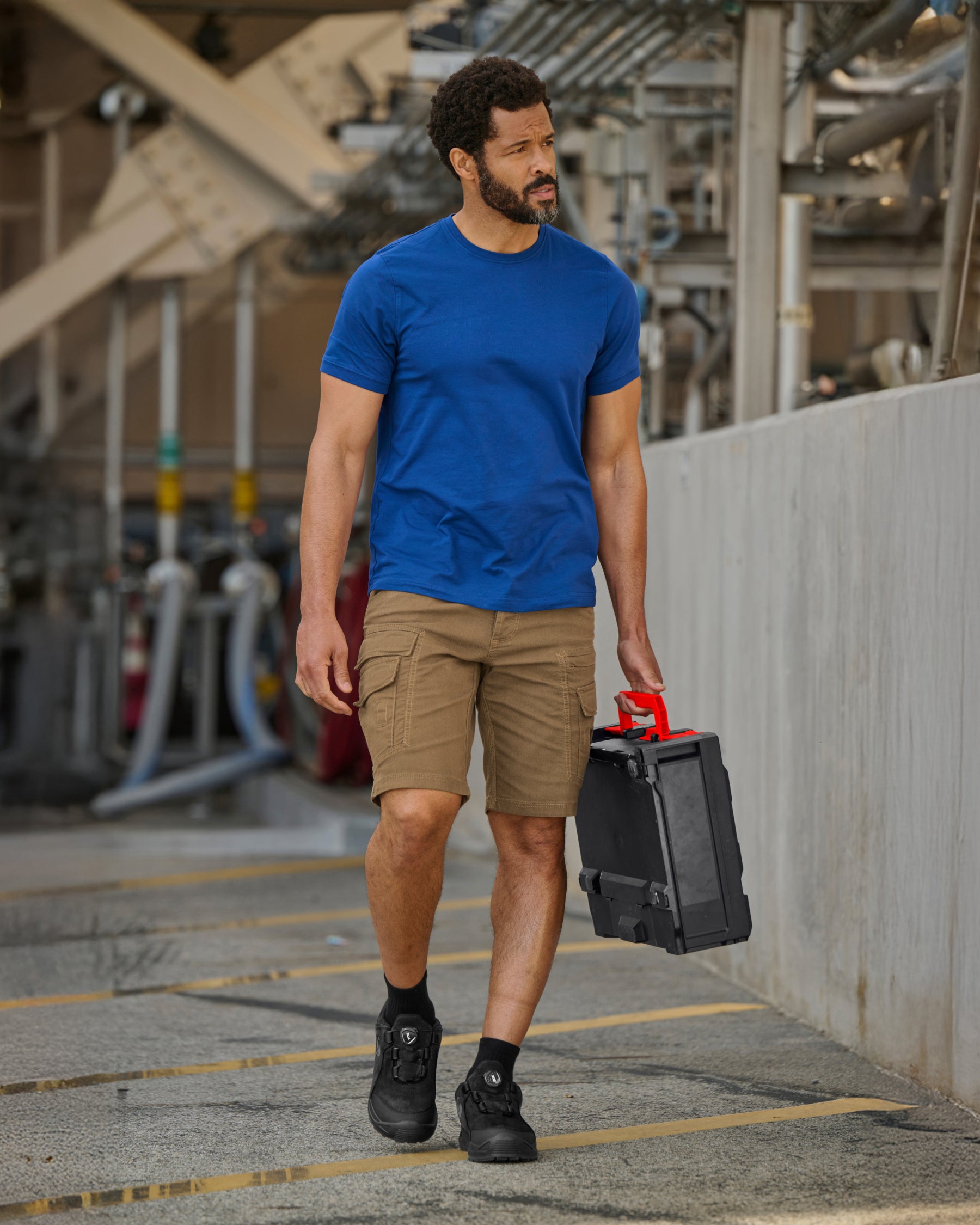 Engelbert Strauss e.s. vintage cargo shorts in sepia in a lifestyle action view, highlighting the practical pocket access and durable workwear silhouette.