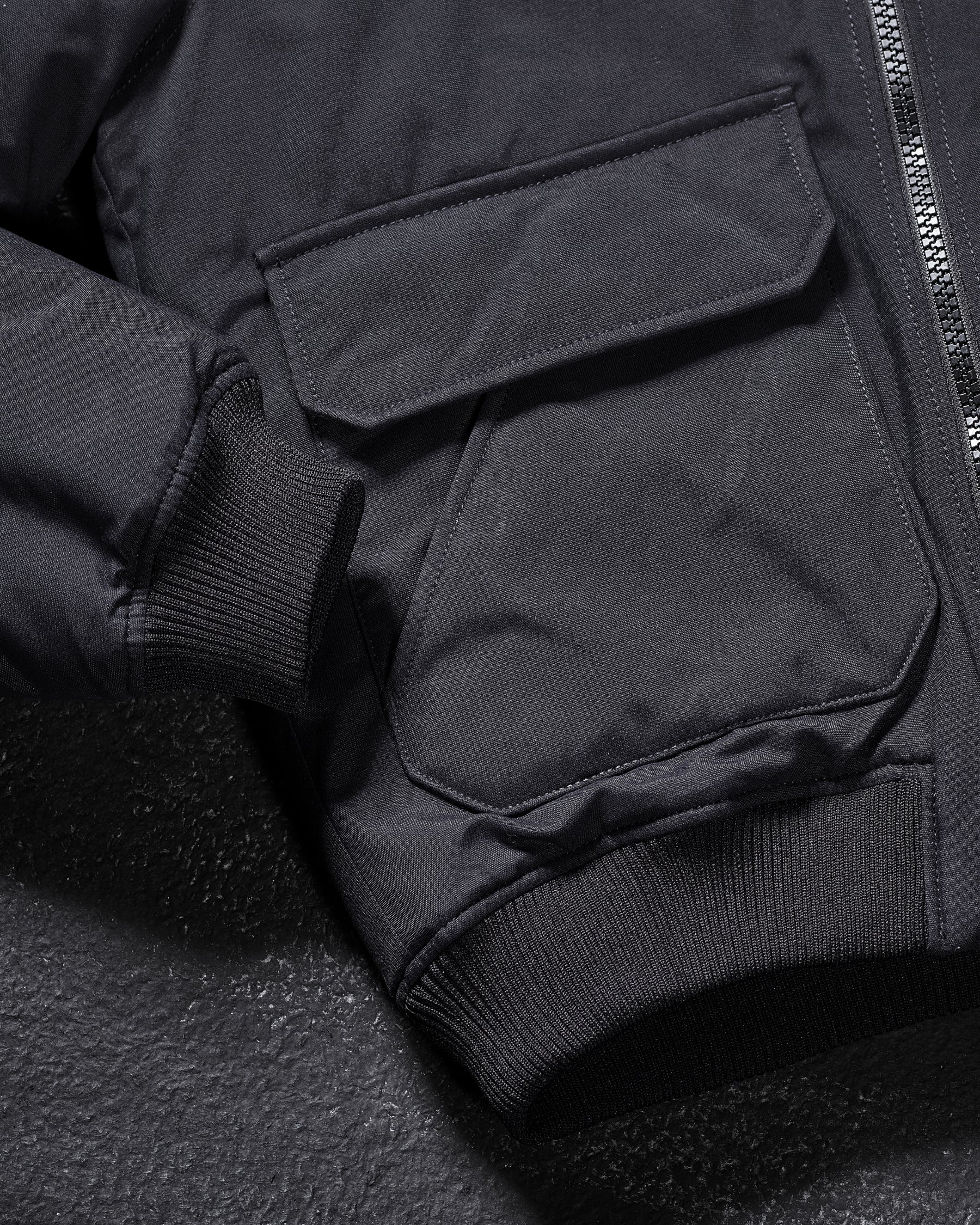 Close-up of ribbed collar and zipper details on STRAUSS e.s.iconic bomber jacket in black