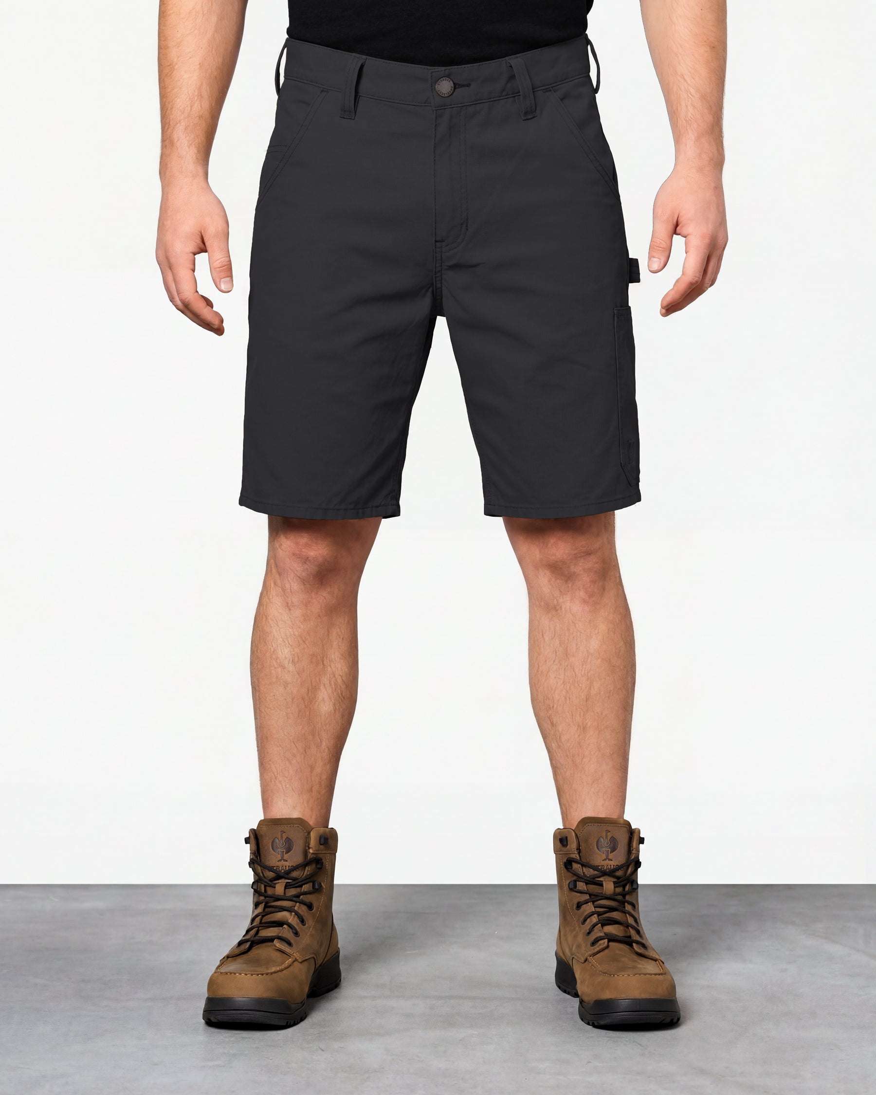 Model wearing Engelbert Strauss e.s. iconic shorts in black, showing the fit, length, waistband, and front pocket layout of the classic work shorts with functional pocket details.