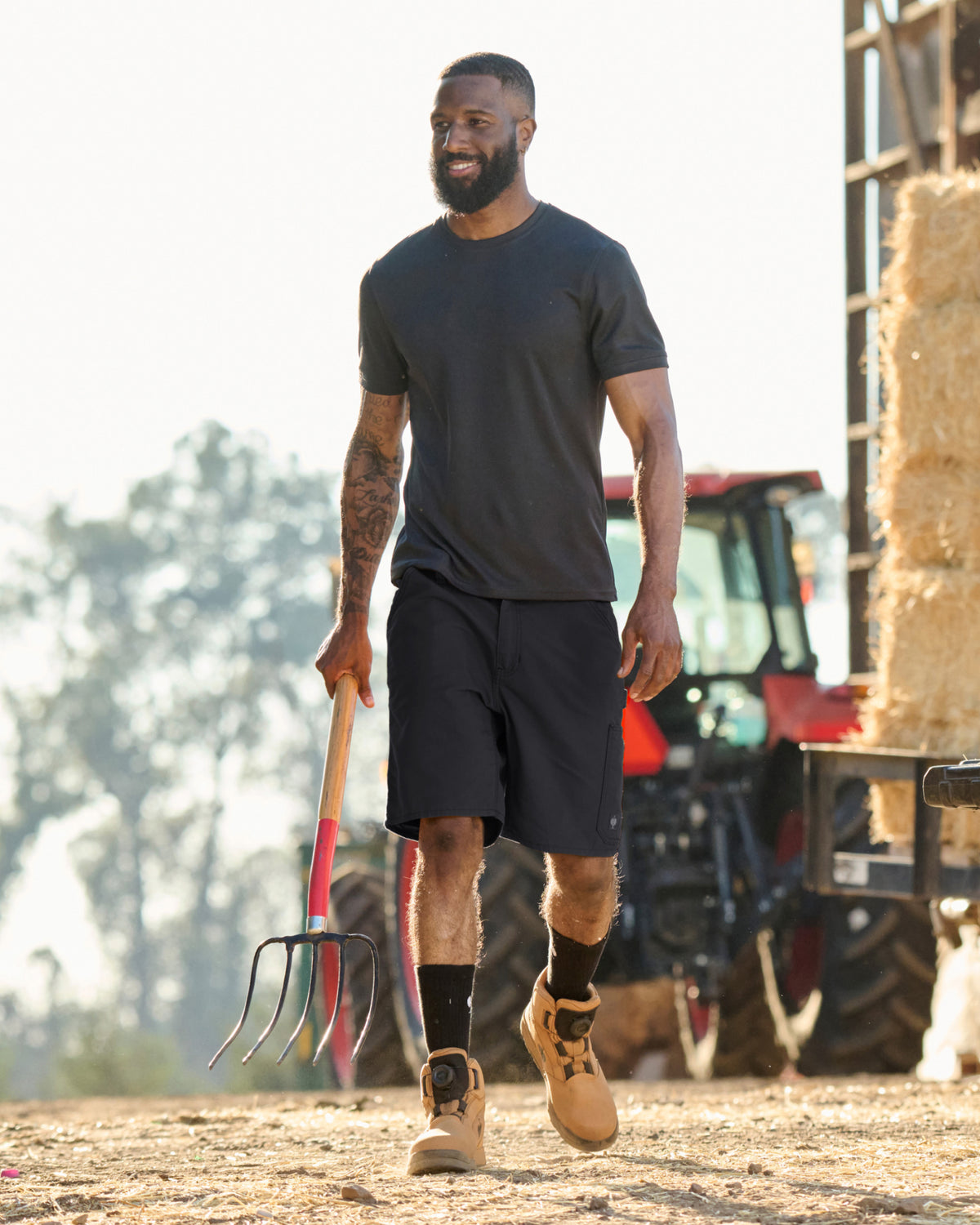 Engelbert Strauss e.s. iconic shorts in black in an outdoor-style lifestyle view, showing the shorts as part of a functional work outfit.