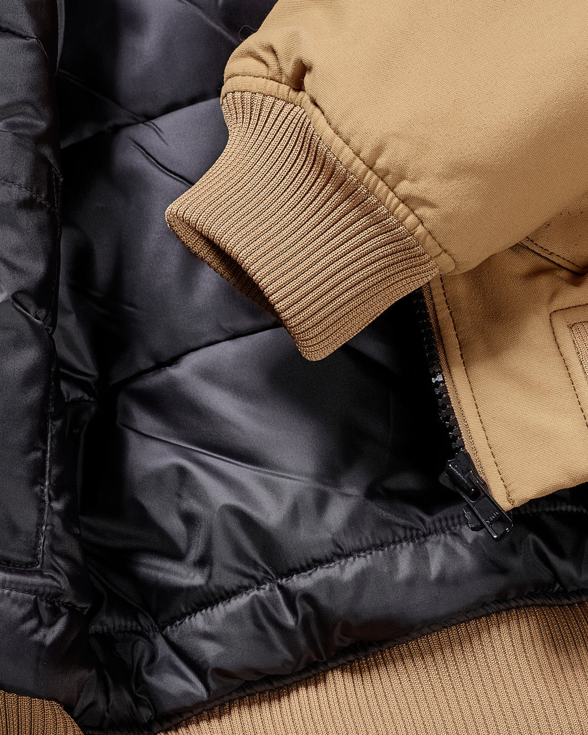 Close-up of pocket and hem details on STRAUSS e.s.iconic bomber jacket in almond brown