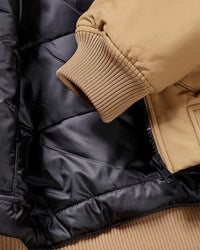 Close-up of pocket and hem details on STRAUSS e.s.iconic bomber jacket in almond brown