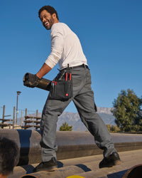 Lifestyle view of Pocket Protected Work Pants e.s.iconic in carbon gray during work