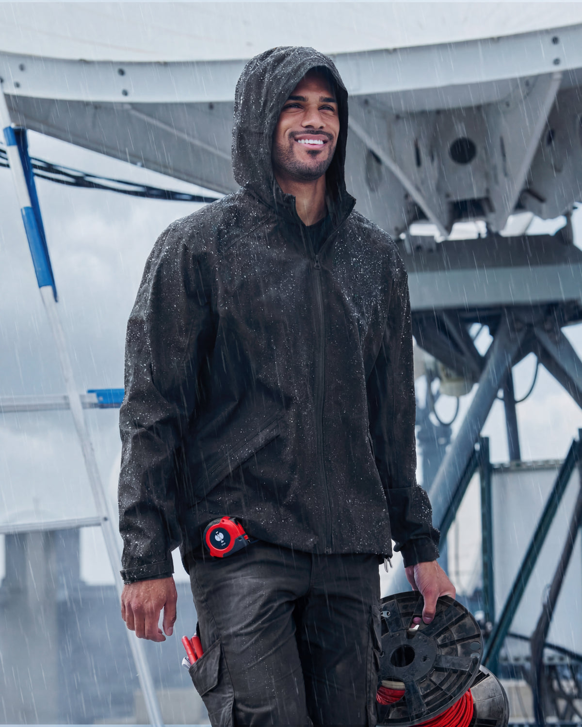 STRAUSS e.s.trail light pack windbreaker in black shown during outdoor work