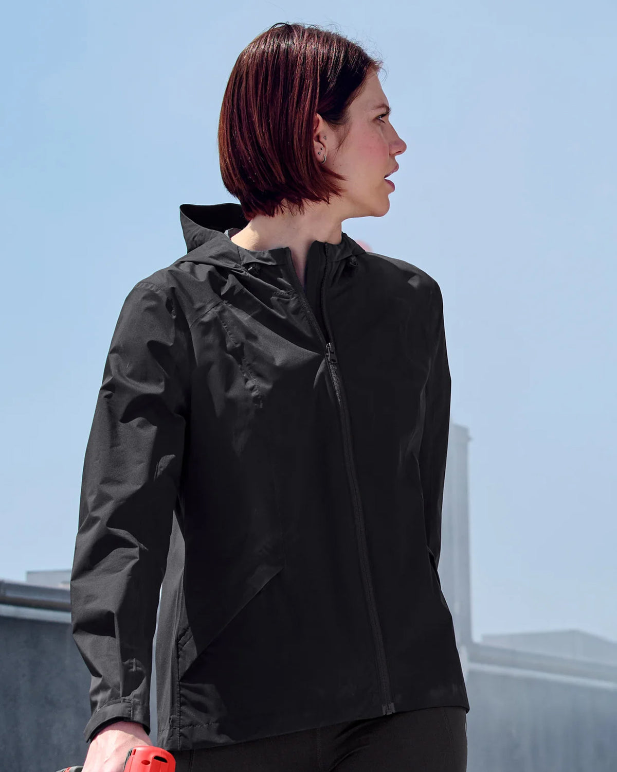 STRAUSS women's e.s.trail light pack windbreaker in black shown during outdoor work