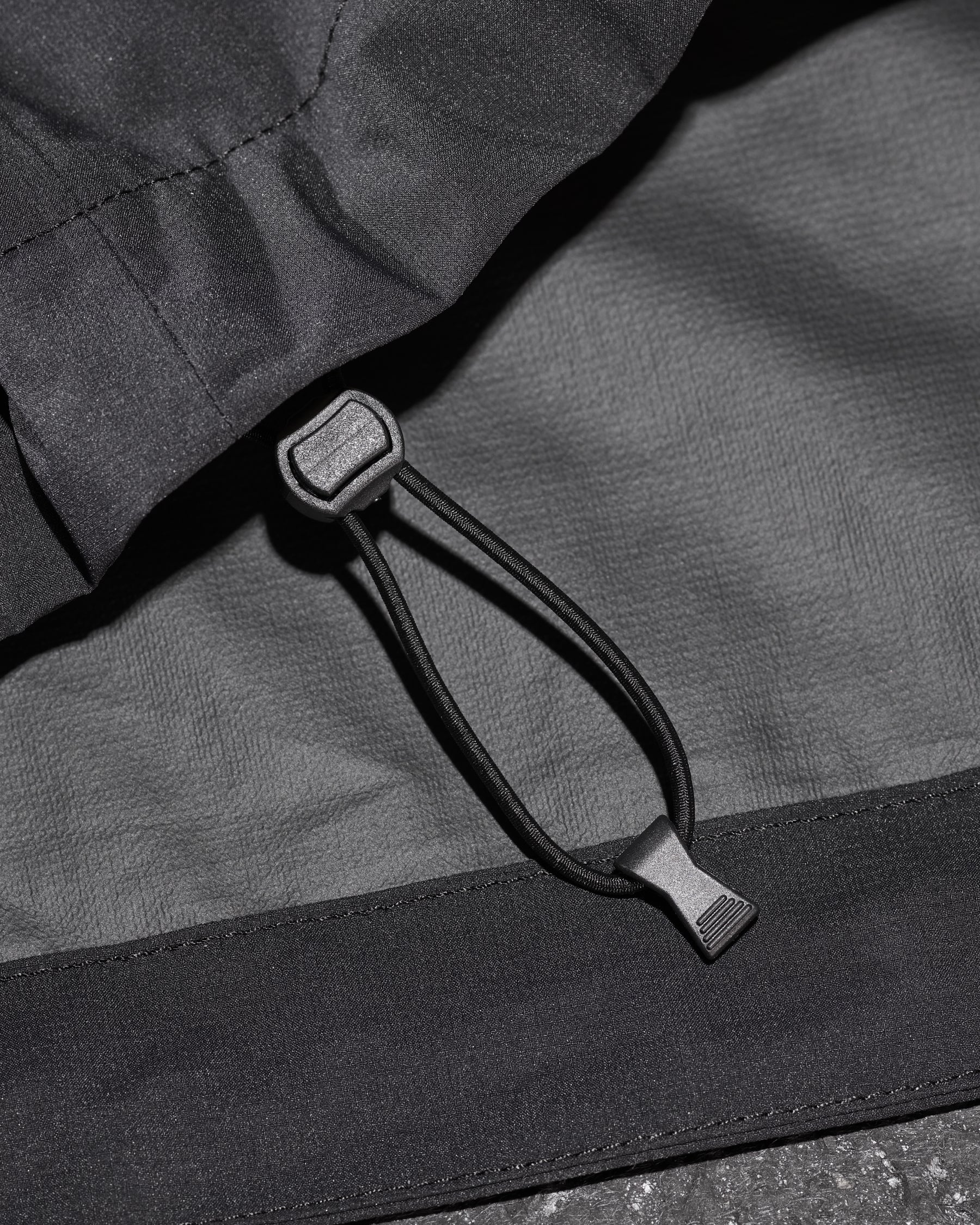 Close-up of packable windbreaker fabric and zipper details on STRAUSS women's e.s.trail light pack windbreaker in black