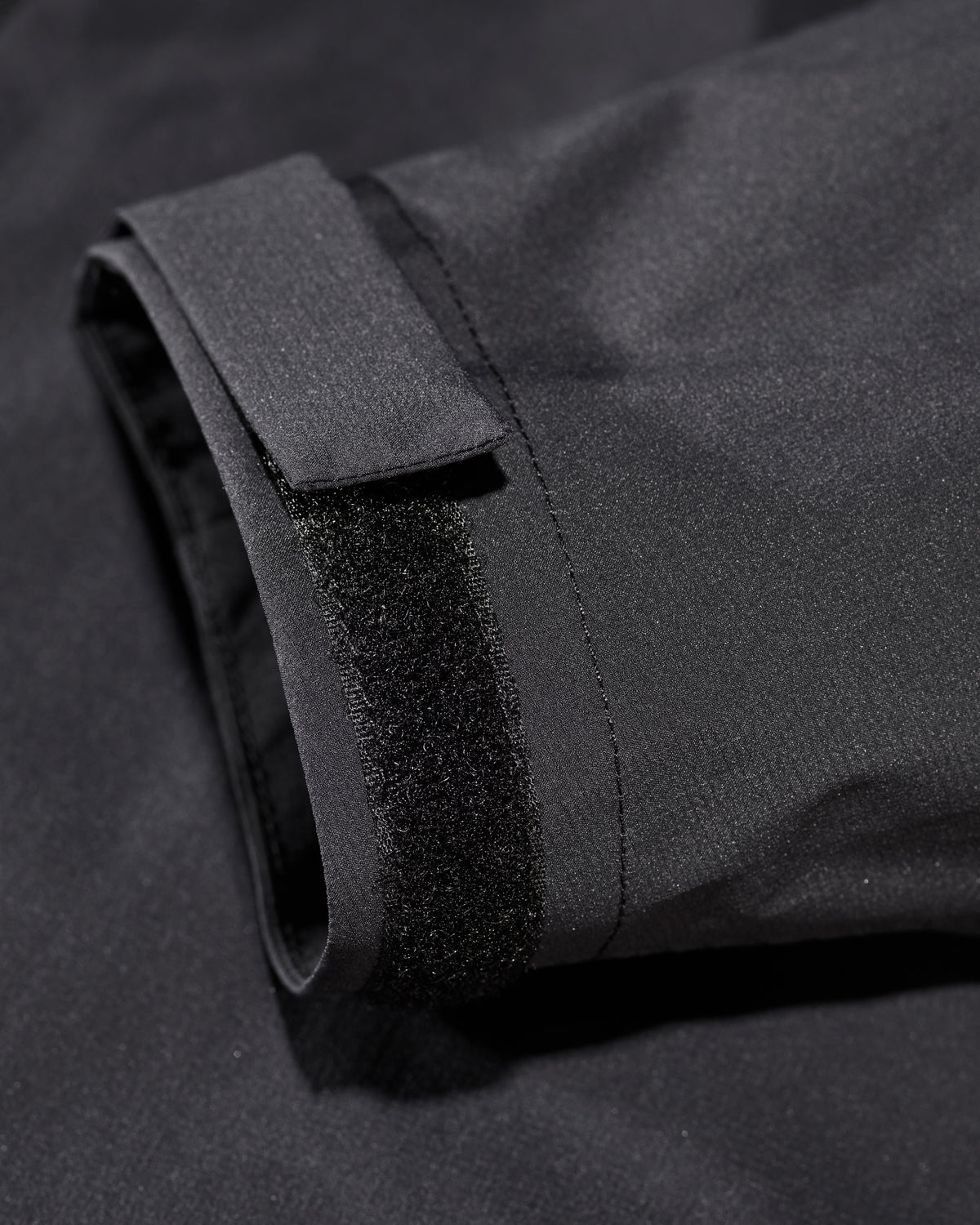 Close-up of hood and pocket details on STRAUSS women's e.s.trail light pack windbreaker in black