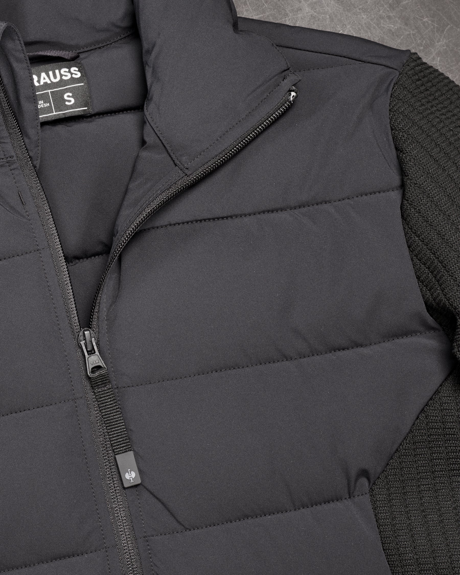 Close-up of quilted and stretch panel details on STRAUSS e.s.trail pure hybrid jacket in black