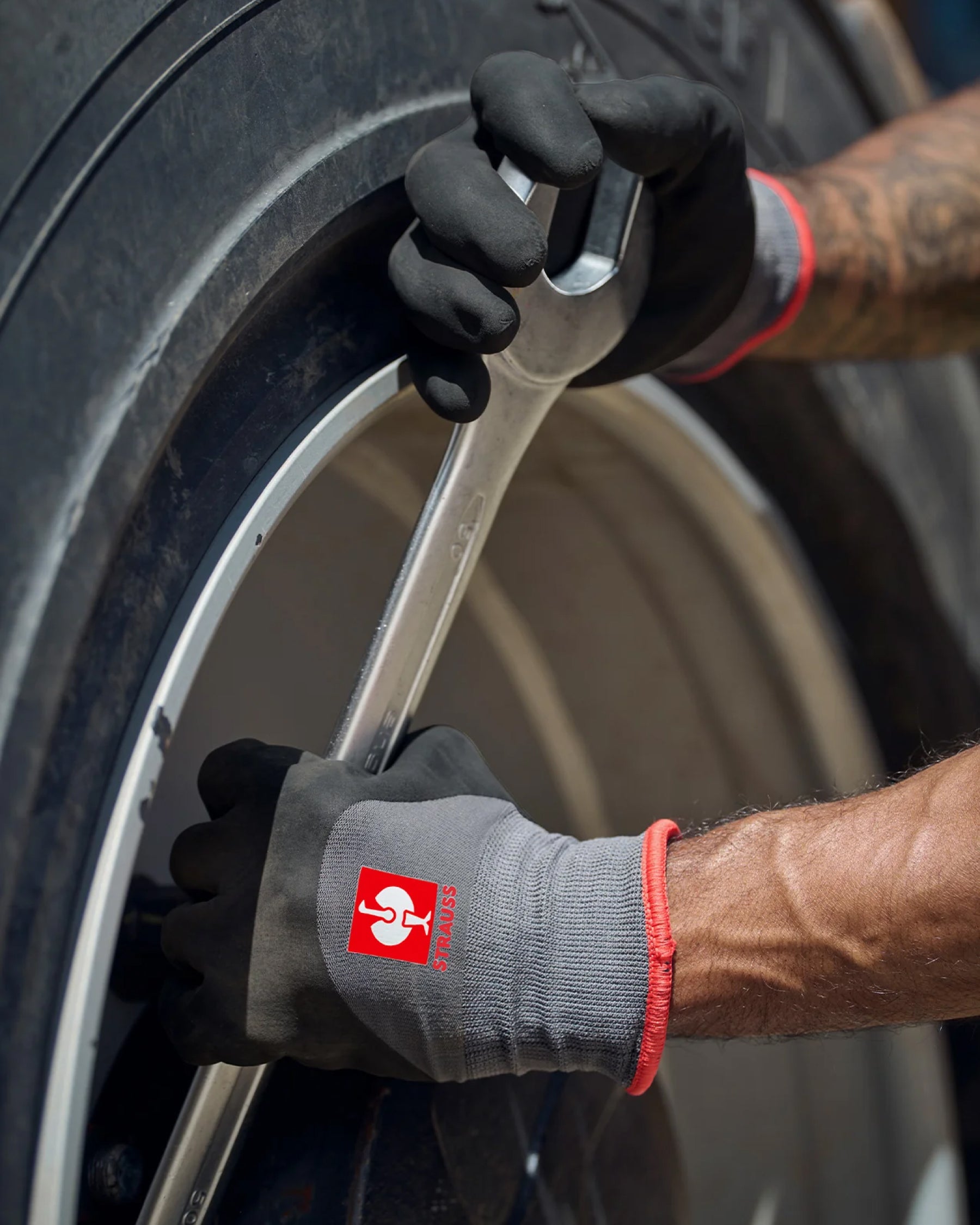 A close work scene shows black and gray STRAUSS evertouch winter nitrile foam gloves protecting hands during a task.