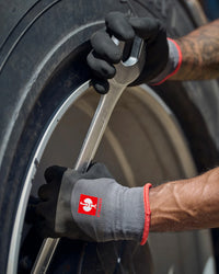 A close work scene shows black and gray STRAUSS evertouch winter nitrile foam gloves protecting hands during a task.