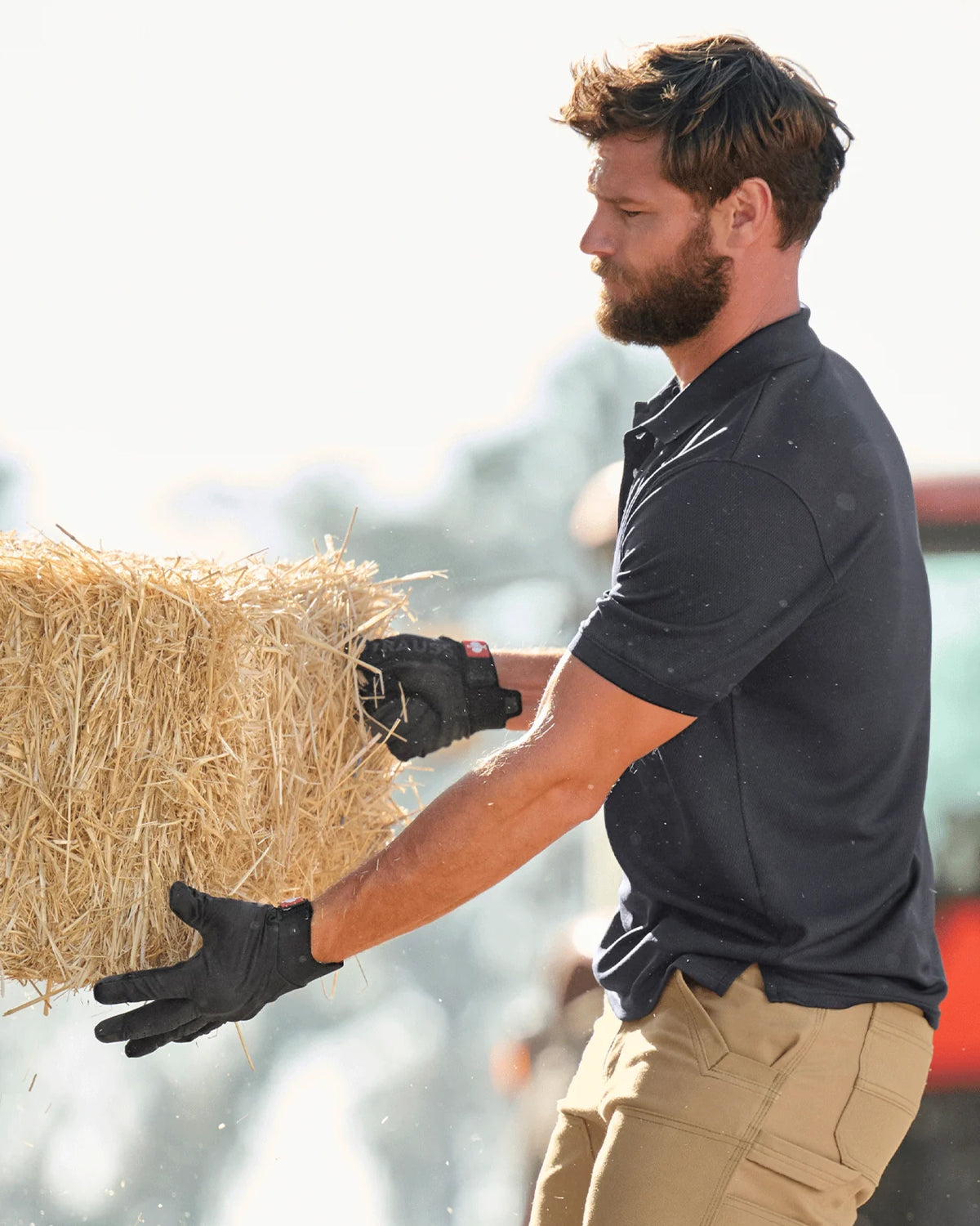 A close work scene shows black STRAUSS e.s.trail all-season gloves protecting hands during a task.