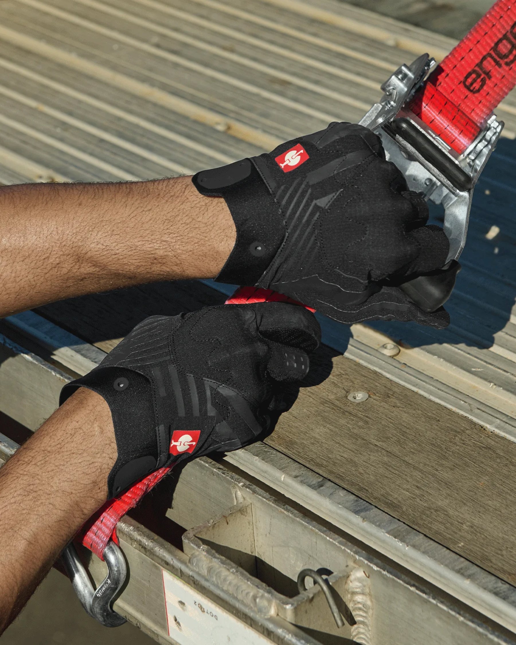A close work scene shows black STRAUSS e.s.trail light graphic mechanic gloves protecting hands during a task.