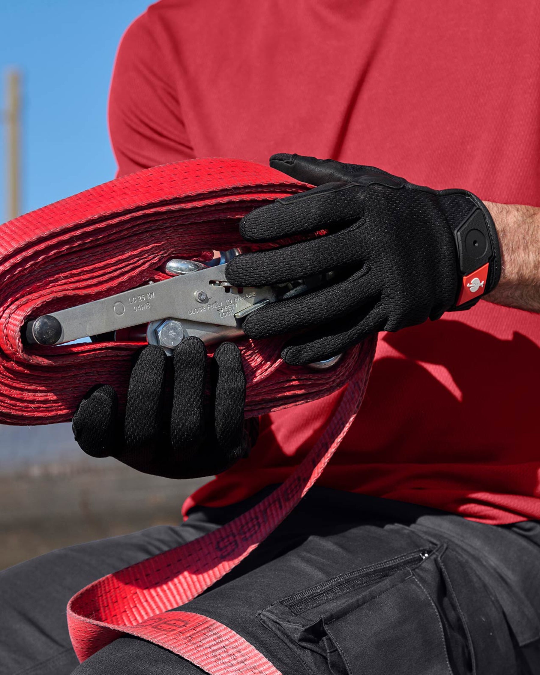 A close work scene shows black STRAUSS light assembly protection gloves protecting hands during a task.