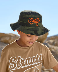A worker wears a camouflage STRAUSS kids' e.s.e:pic bucket hat with a work shirt outdoors.