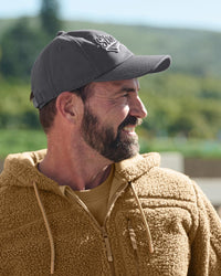 A model wears a carbon gray STRAUSS e.s.e:pic cap with a casual STRAUSS workwear outfit.