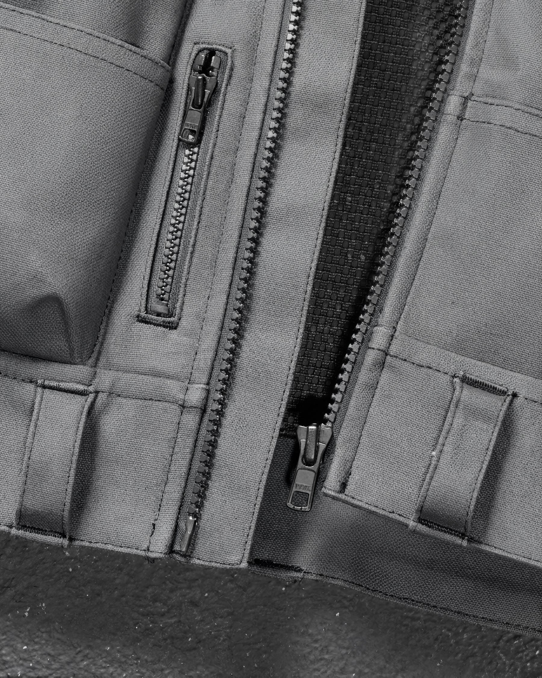 Close-up of tool pockets and storage details on STRAUSS e.s.iconic tool vest in carbon gray and black