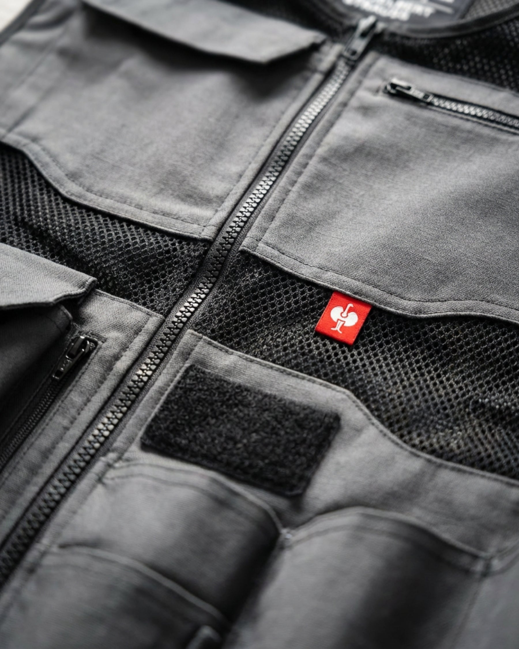 Close-up of reinforced pocket and closure details on STRAUSS e.s.iconic tool vest in carbon gray and black
