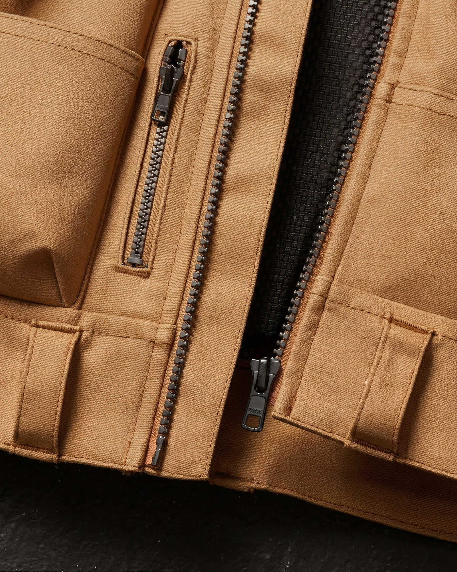 Close-up of tool pockets and storage details on STRAUSS e.s.iconic tool vest in almond brown and black