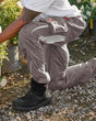 Black STRAUSS flex knee pads are shown inserted in work pants during a kneeling task.