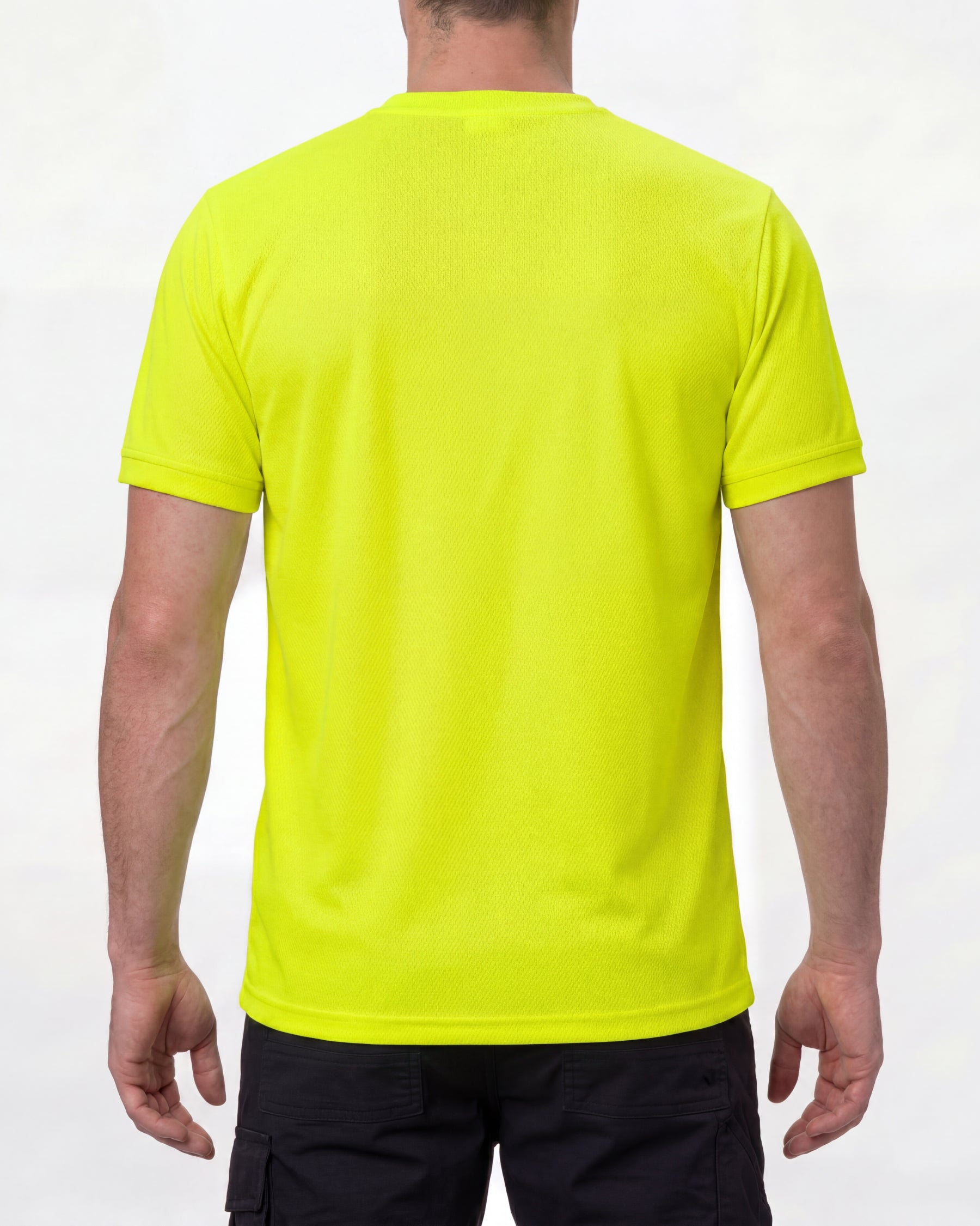 A model wears the STRAUSS Enhanced Visibility Performance T-Shirt in neon yellow with dark work pants and work boots, showing the shirt fit